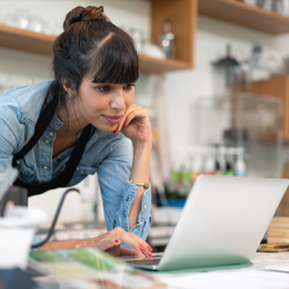 Woman leaning over her laptop in a coffee talk or cafe