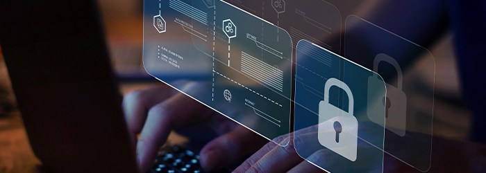 Laptop with person's hands on the keyboard and a holographic image of a padlock and internet security