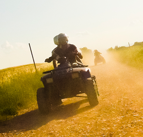 rides on 4-wheeler on dusty road