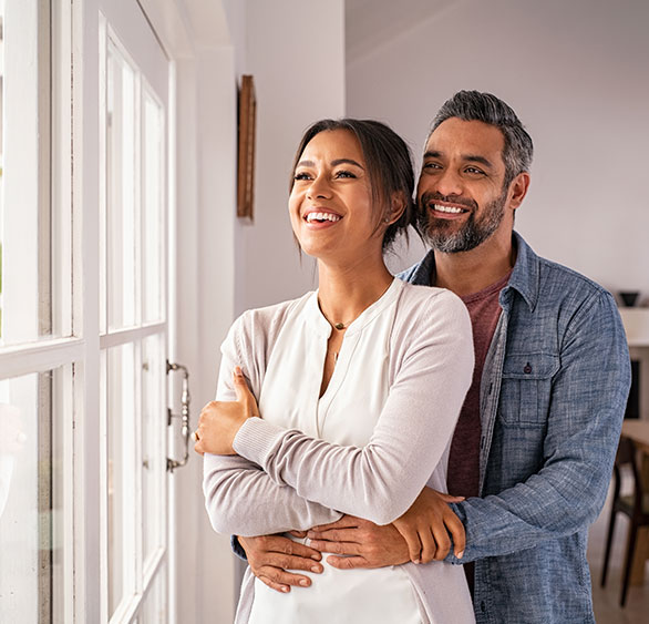 man and woman looking out sunny window